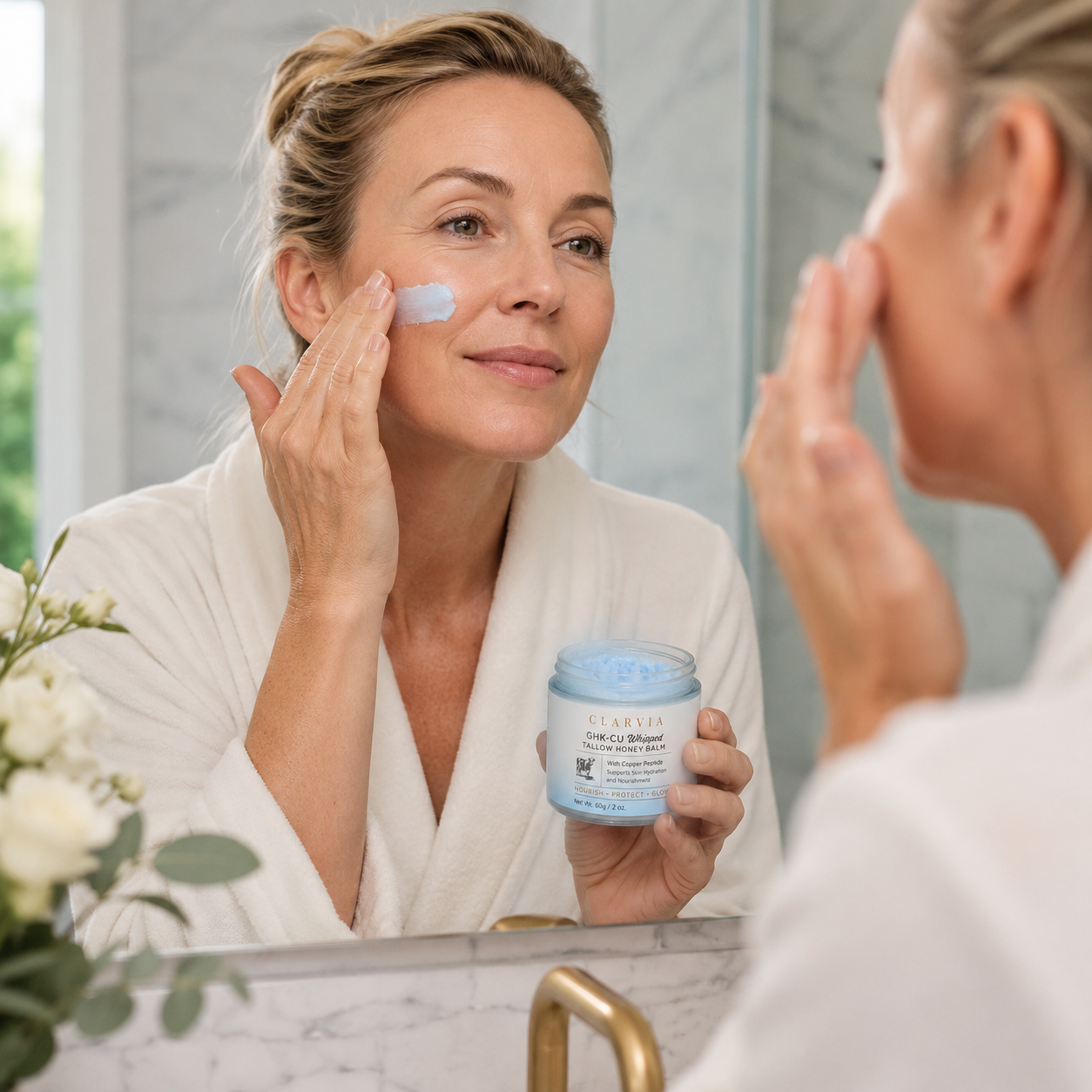 A woman applying Clarvia balm at her bathroom mirror.